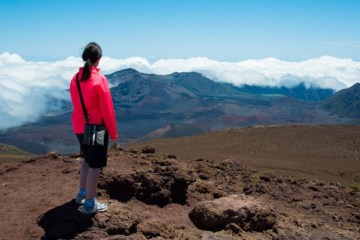 a woman looking at a maui volcano